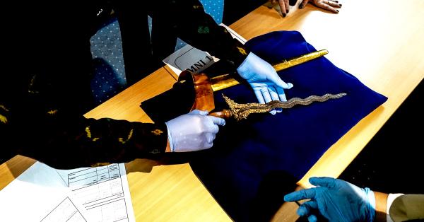 Para staf Museum Nasional memeriksa kondisi keris saat tiba di Jakarta. (Fernando Randy/Historia).