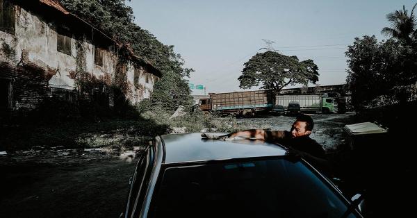 Seorang warga sedang mencuci mobil di kawasan bekas gudang Kastil Batavia. (Fernando Randy/Historia.id).