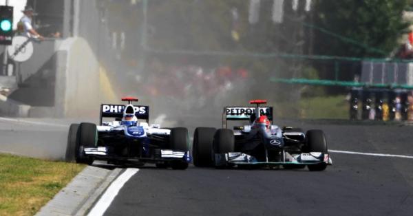Kelakuan Schumi (kanan) kala menjepit Rubens Barrichello ke pagar pembatas sirkuit di GP Hungaria 2010 (Foto: formula1.com)