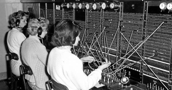 Operator di sentral telepon bekerja di depan papan hubung. Sumber: Sunshine Coast Daily