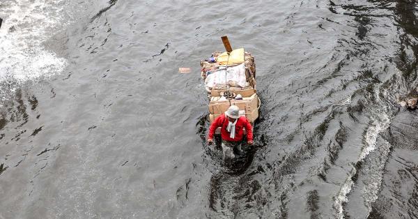 Seorang pemulung berusaha melewati banjir di Jakarta. (Fernando Randy/Historia).