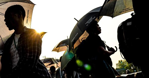 Massa aksi Kamisan dengan ciri khas mereka baju dan payung hitam. (Fernando Randy/Historia).