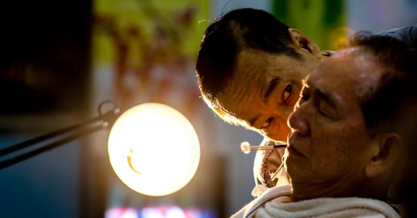 Pi Cis saat membersihkan telinga salah satu pelanggan Ko Tang. (Fernando Randy/Historia).