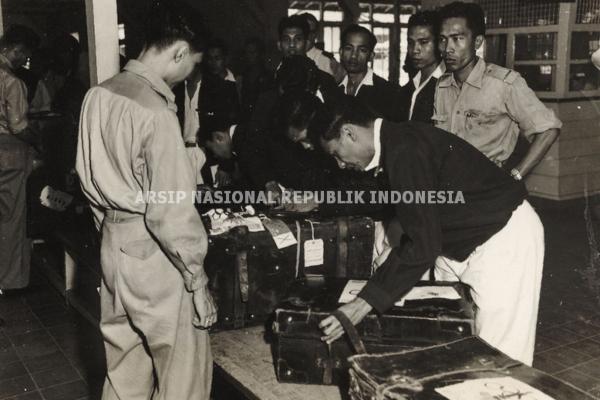 Petugas Bea dan Cukai sedang memeriksa koper milik atlet peserta Asian Games di Lapangan Terbang Kemayoran, Jakarta. (ANRI).
