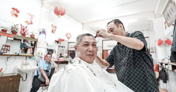 Pelanggan setia pangkas rambut Ko Tang, Zakharia saat dicukur oleh Pi Cis. ( Foto : Fernando Randy )