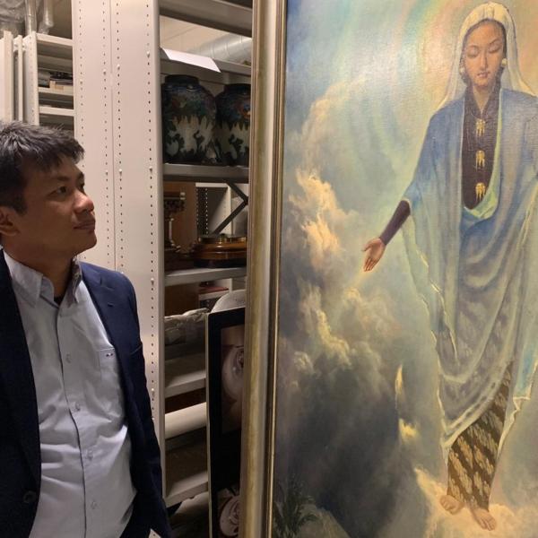 Bonnie Triyana, pemimpin redaksi Historia.id, melihat lukisanMaria Assumpta karya Basoeki Abdullah. (Bonnie Triyana/Histori