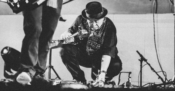 Donny Suhendra sedang menyetel gitarnya. (Fernando Randy/Historia).