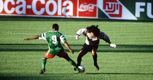 Roger Milla (kiri) kala mencuri bola dari kaki José René Higuita Zapata (fifa.com)