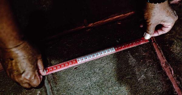 Sang cucu Yanto saat mengukur luas tanah dan lantai di rumah sejarah rengasdengklok. (Fernando Randy/Historia.id).