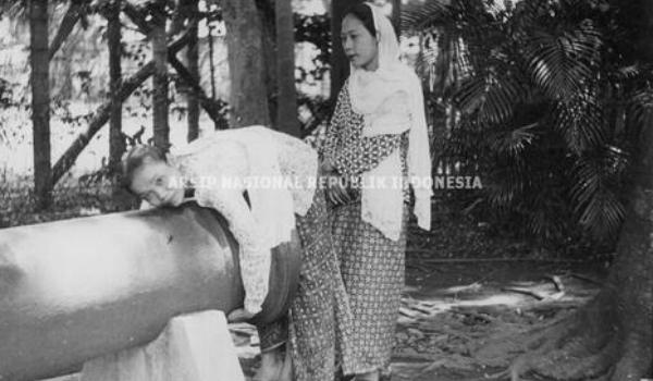 Seorang perempuan sedang memeluk Meriam Si Jagur tahun 1951. (ANRI).