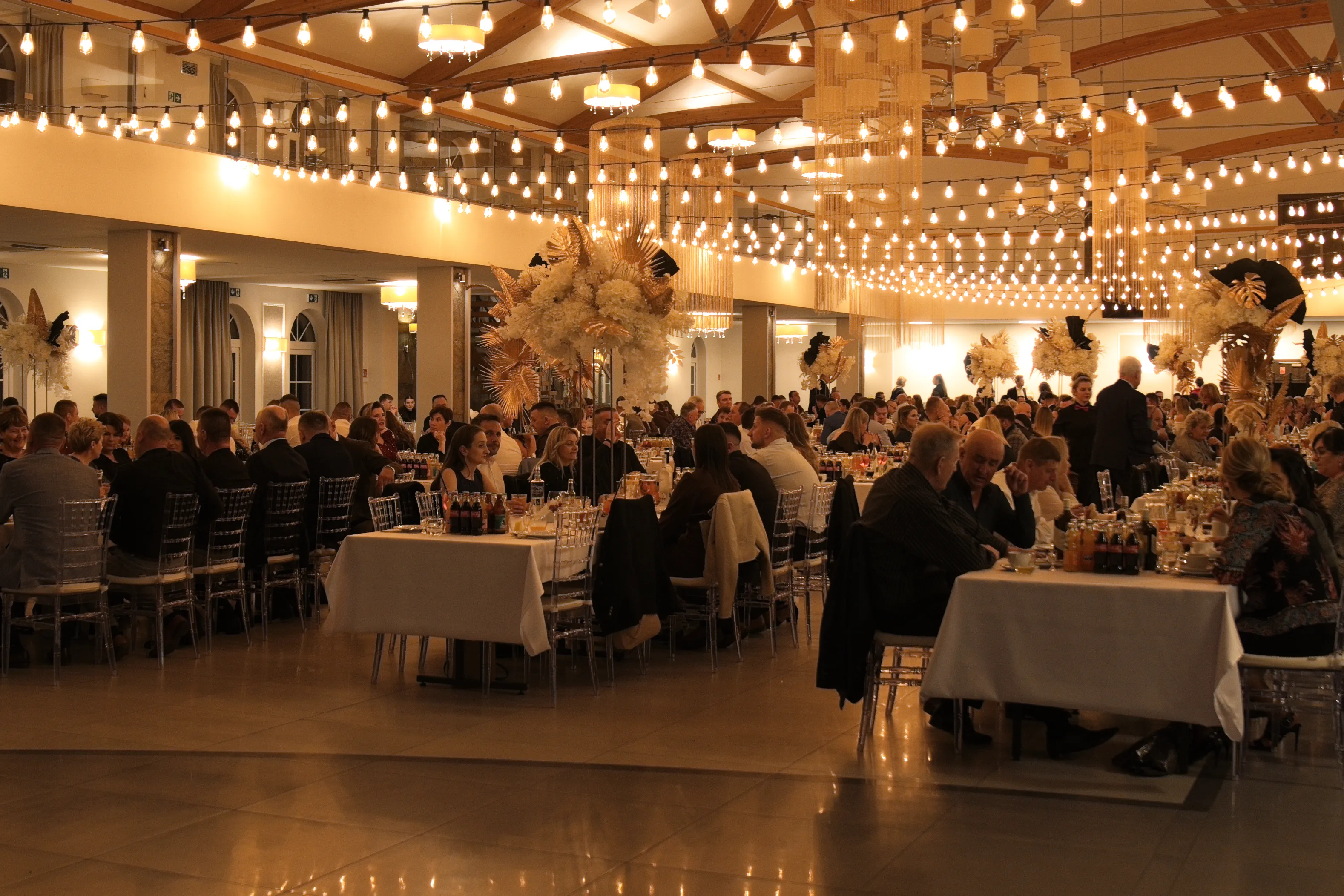 Ludzie siedzący przy stołach udekorowanej sali weselnej w Gościńcu w Czuszowie