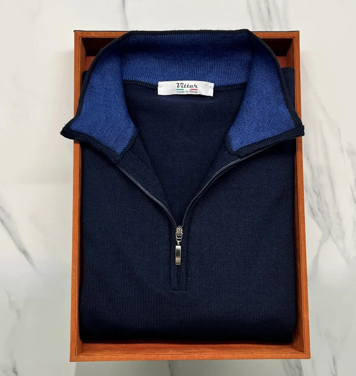 A navy merino wool light weight sweater with azure inner collar