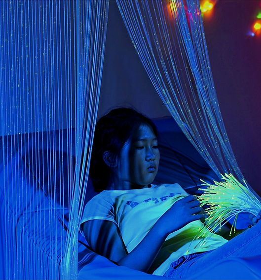 a girl relaxing with a bead curtain and fibre optic tails