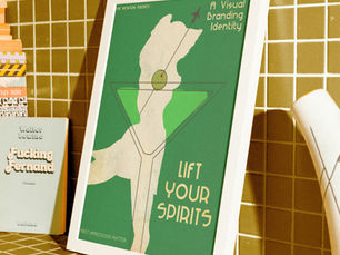 Green framed poster on mustard-tiled shelf reads A Visual Branding Identity and LIFT YOUR SPIRITS, with a stylized figure.