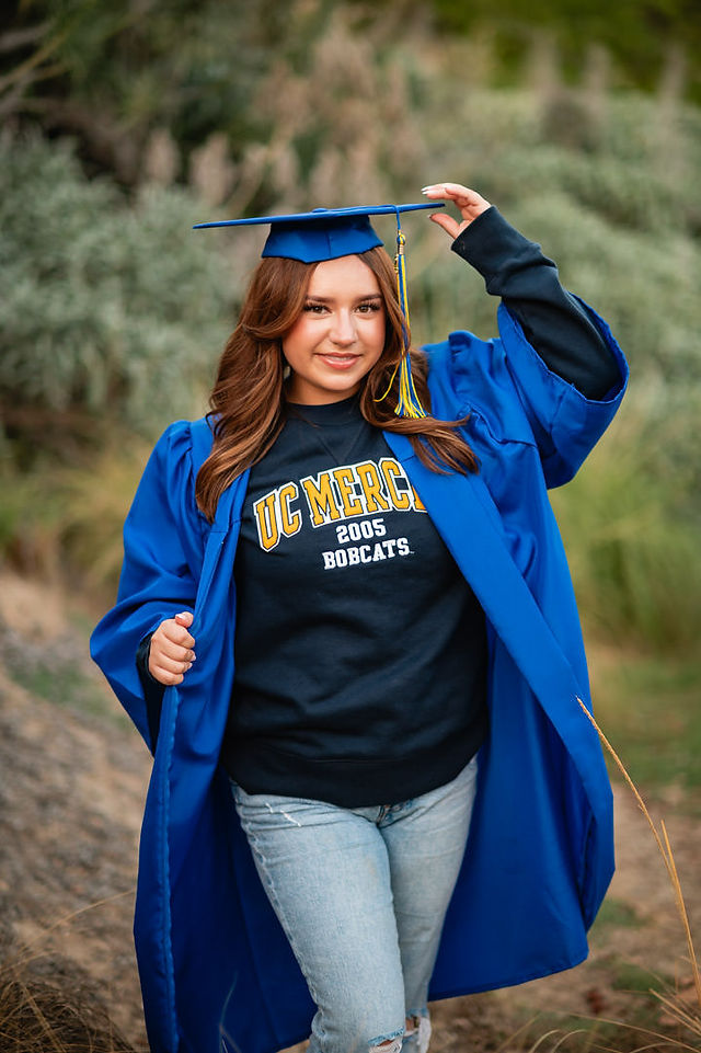 Young women posing in a blue cap and gown