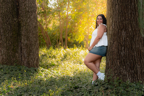 Senior portraits of a girl leaning against a tree