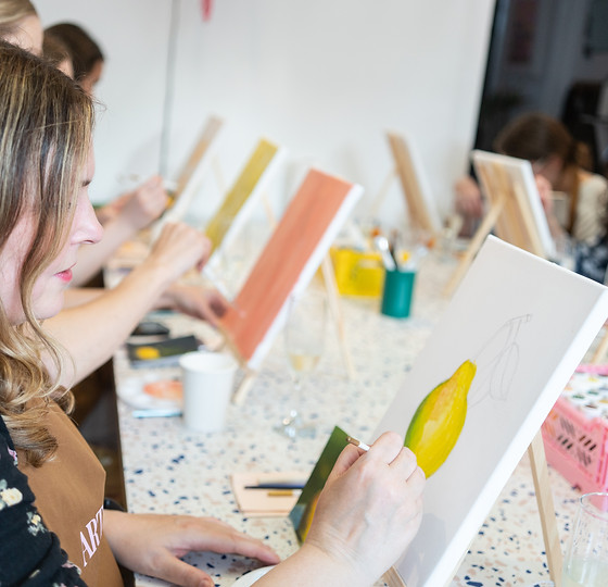 Art and Fizz painting party; group of peaple holding brushes and painting canvases.