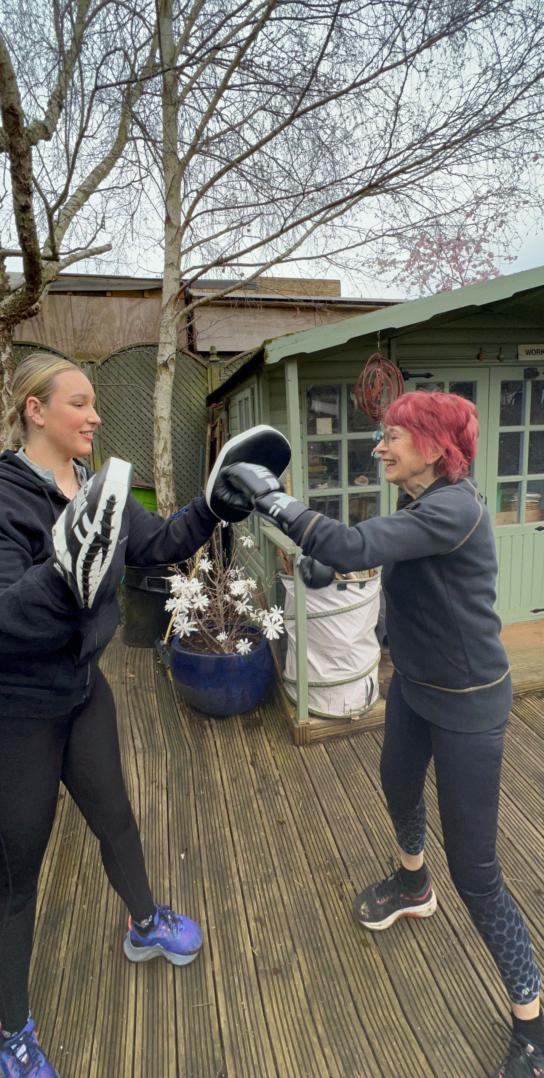 Personal trainer with client boxing outside