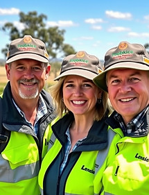 Three people looking at the camera smiling while wearing high-vis clothing and peaked caps