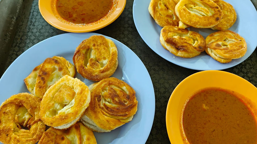Plates of fried pastries on blue plates with orange bowls of spicy soup on a patterned table, creating a warm, inviting scene.