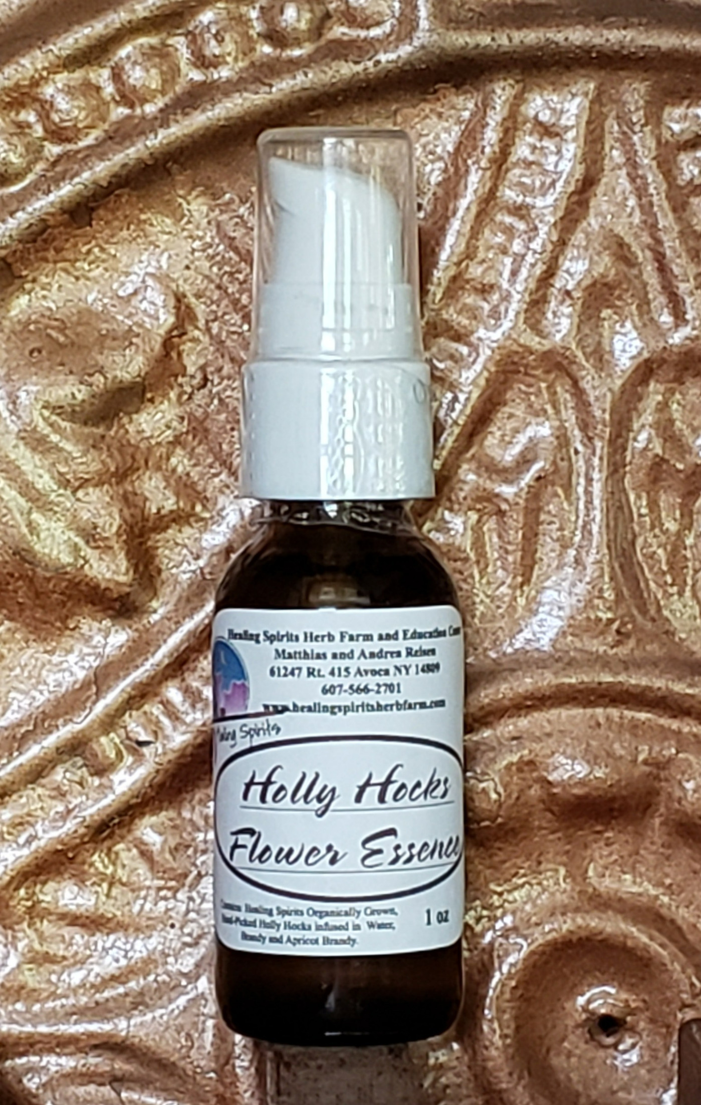 Hollyhock Flower Essence bottle against a soft background.