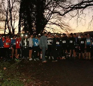 Coureurs rassemblés au coucher du soleil sur la ligne de départ du Vertrail : course nocturne en forêt de Porchefontaine à Versailles.