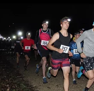 Coureurs lancés sur les pistes du Vertrail : course nocturne en forêt de Porchefontaine à Versailles.