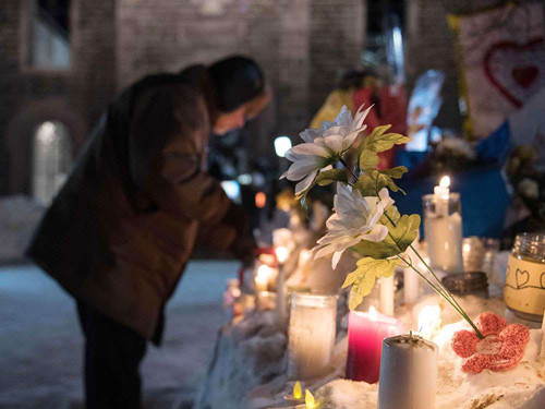 People place candles at a memorial two days after the fatal shooting spree at a Quebec City mosque on Jan. 29, 2017.