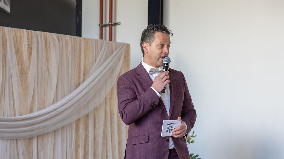 Professionele dagvoorzitter tijdens zakelijk evenement met publiek en sprekers