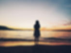photo of artist Lydia Chen taken from the back, with sunset at the background