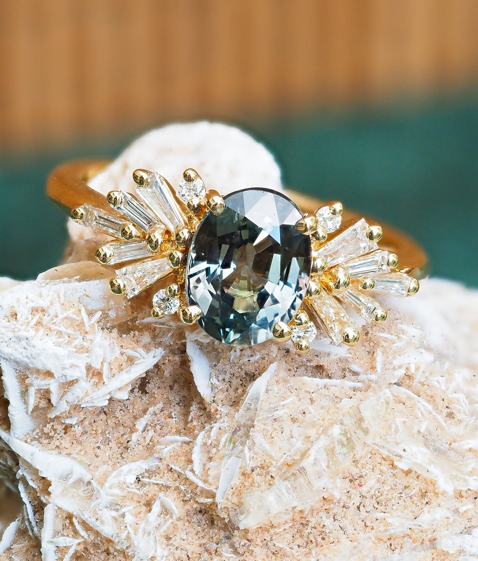 Bague Estrella en or jaune 18 carats, sertie d’un saphir ovale gris-vert de 2,08 ct aux reflets bleutés, entouré de diamants en éventail.