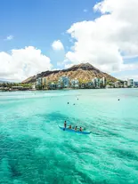 Waikīkī outrigger canoe tour group exploring the ocean with Diamond Head in the distance