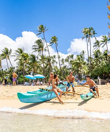 Guests preparing for a canoe tour on the shore of Kaimana Beach in Waikīkī