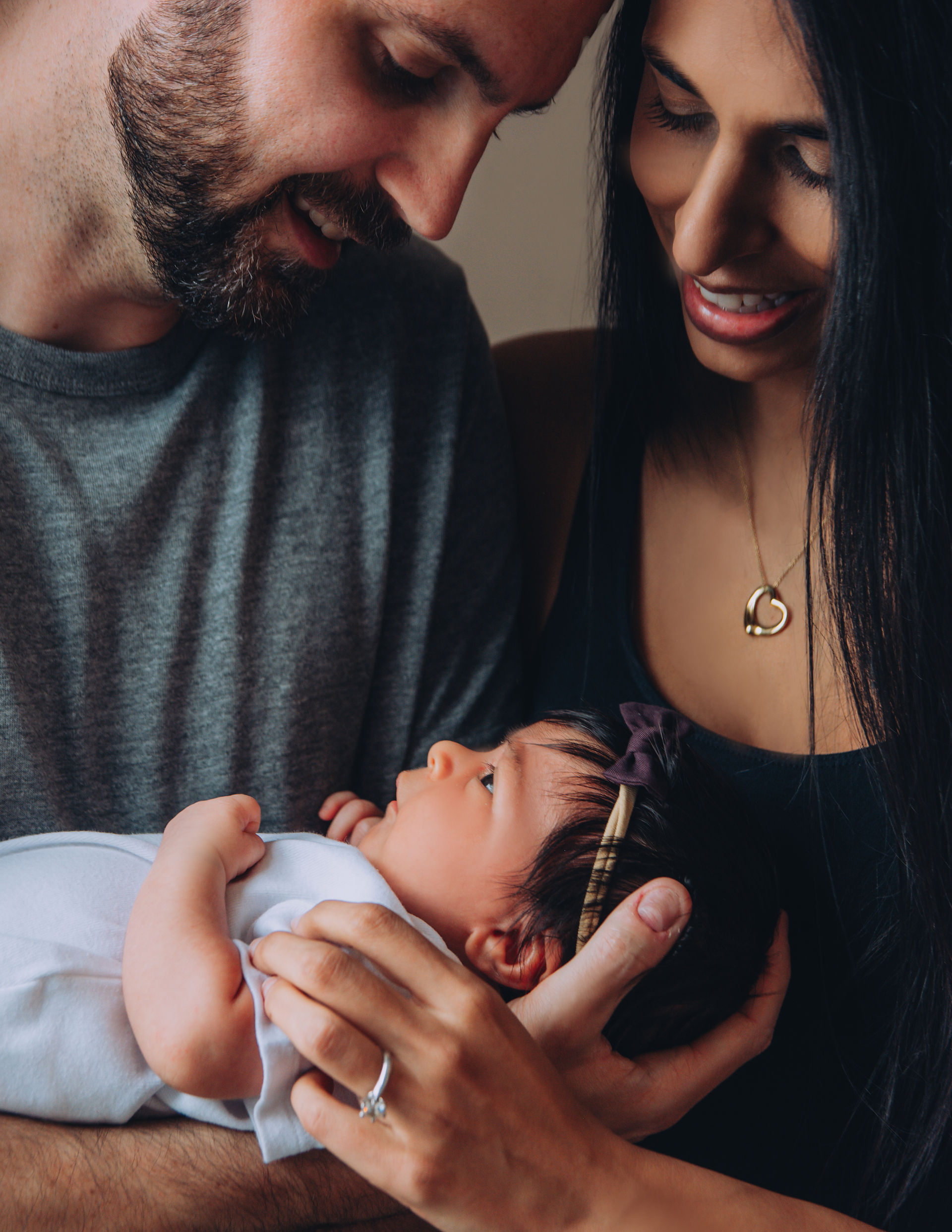 Simple studio maternity photo with plain beige backdrop and soft tones