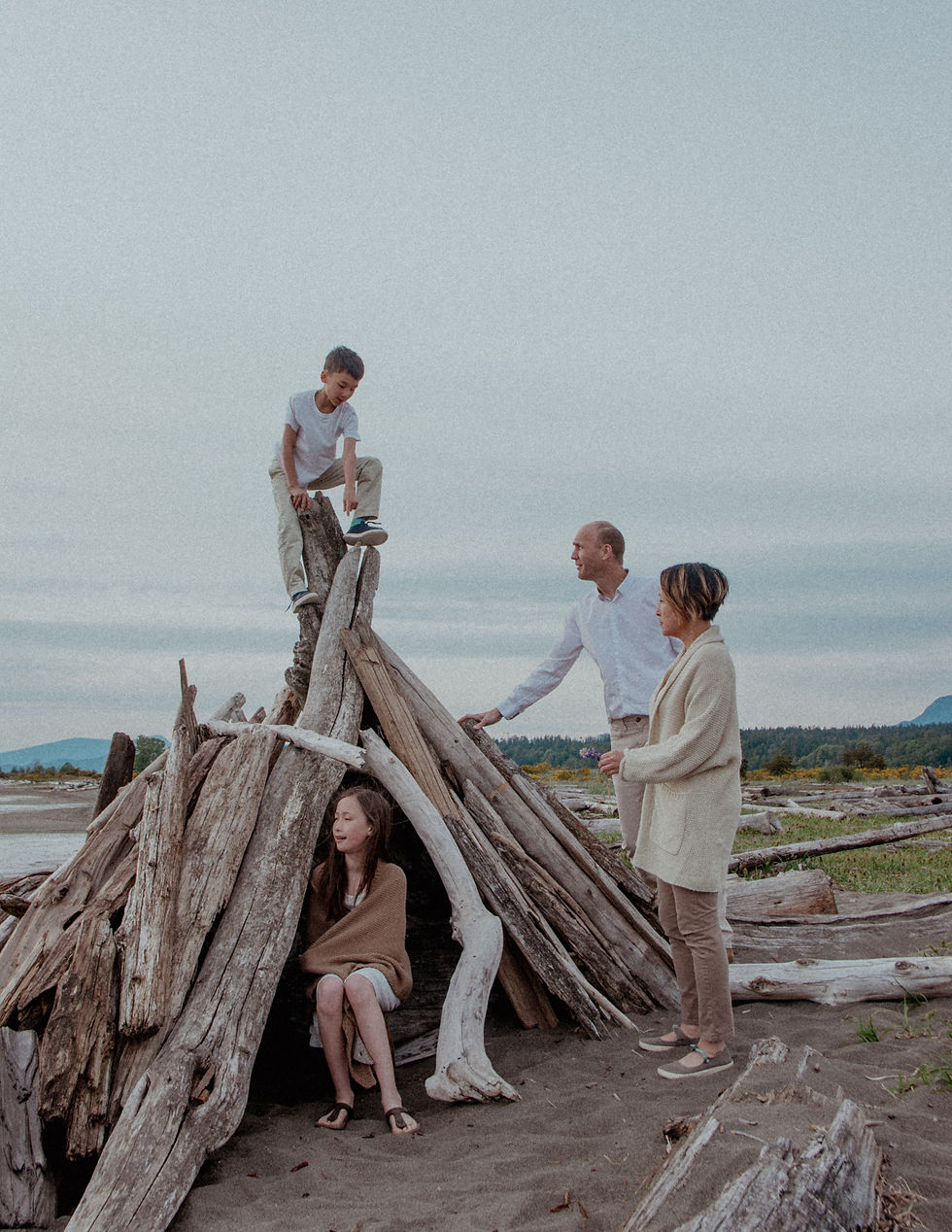 Family playing around a driftwood fort at Iona Beach in Richmond – candid outdoor photo session by My City Photos.