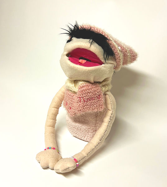 Pink Puppet wearing a scarf and hat with his mouth open