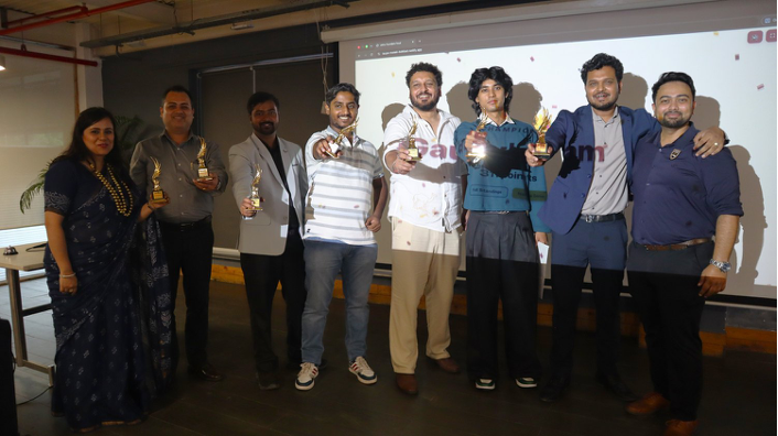 The winning team holds their trophies on stage after Founders Feud at the Unhu Founders Meet, Dehradun.