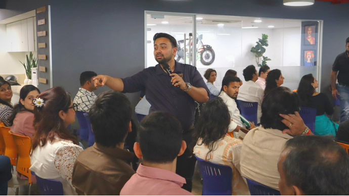Founders seated at the Unhu Founders Meet inside Iksana Workspaces, Dehradun, as a speaker addresses the room with a microphone.