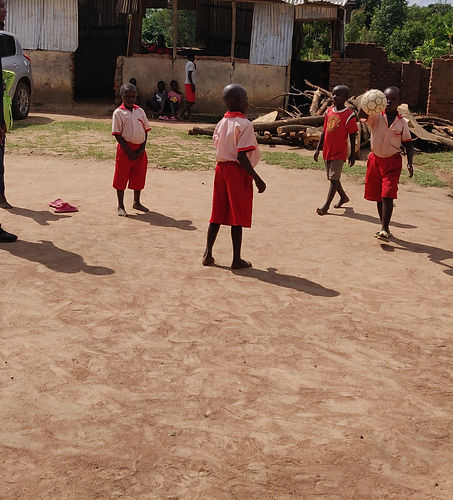 Children in front of the temporary classrooms, playing football