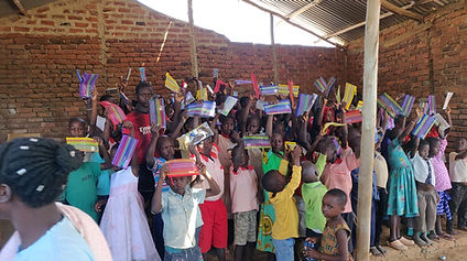 Children holding up their new stationery.