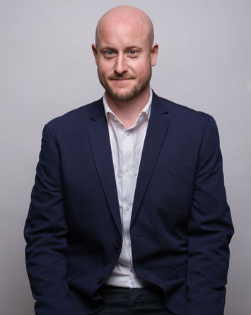 Ritratto aziendale  a colori di dirigente su fondo grigio 