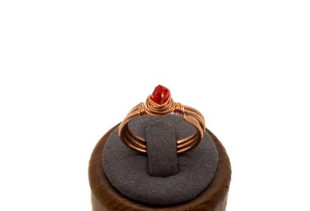 Thumbnail: Hand textured copper three banded ring with a scarlet Swarovski crystal framed in a hand wrapped wire birds’ nest.