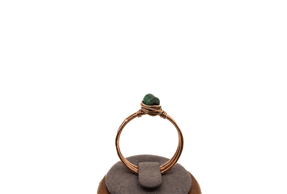 Hand textured copper three banded ring with malachite gemstone framed in a hand wrapped wire birds’ nest.