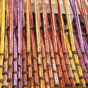 Multicolored yarn being woven on a loom