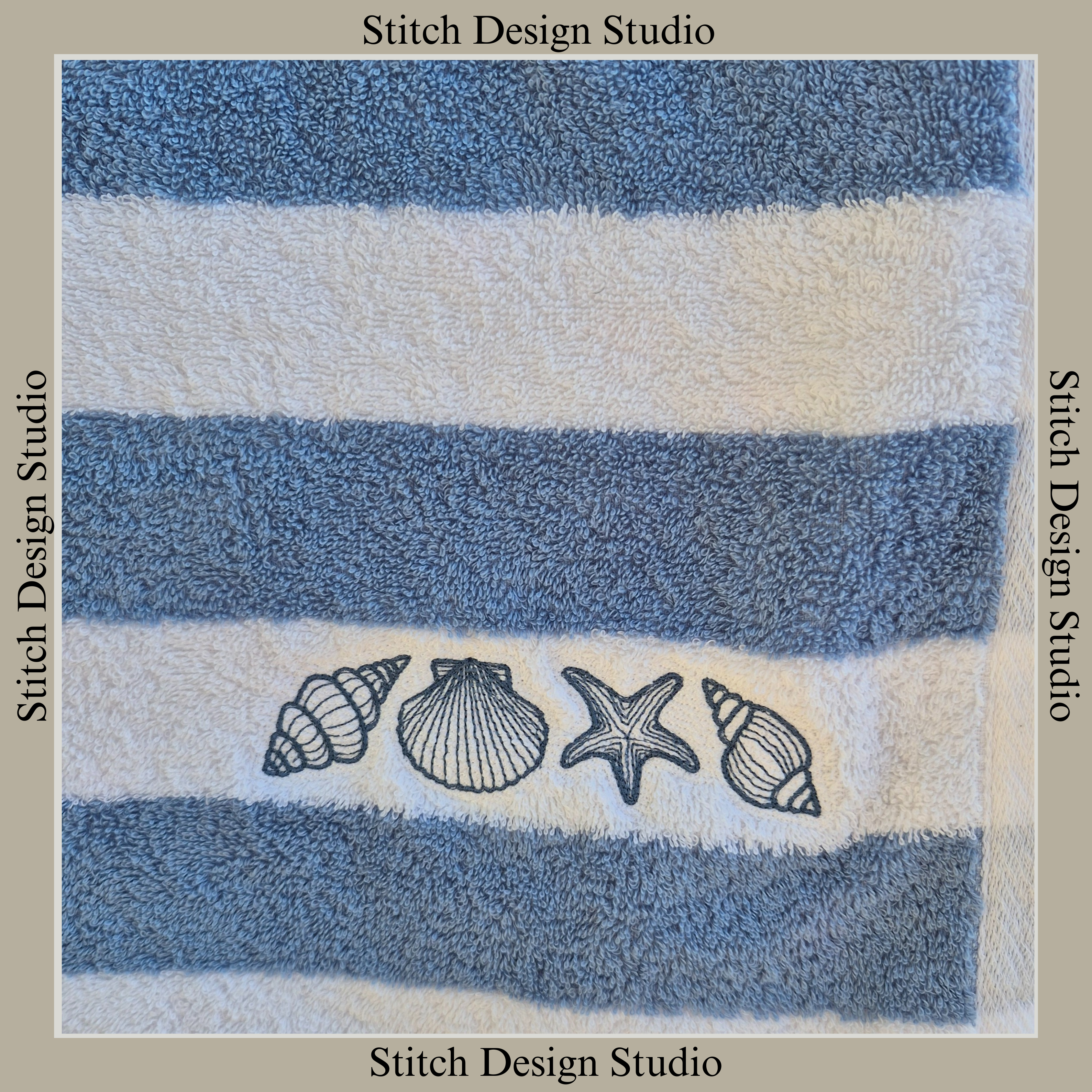 A blue and white stripey towel embroidered with 3 seashells and a starfish in blue thread.