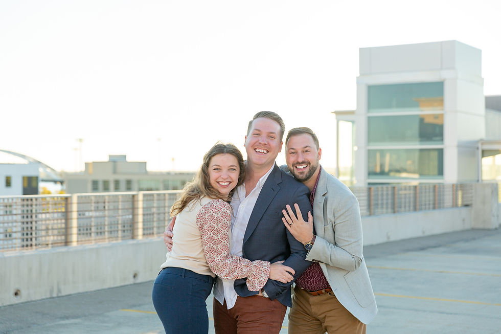 The BKP Team, including Hannah Thomsen, Brandon Kane, and Forest Kane, hugging on top of a parking garage in Davenport, Iowa. Captured by Brandon Kane Photography, a professional Quad Cities wedding and engagement photography team.