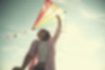Woman flying a colorful kite across the sunny sky