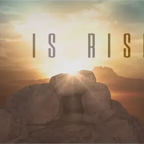 He is Risen written over empty tomb and sunrise