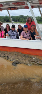 Happy group of travelers on a private safari boat on the Tarcoles River, Costa Rica
