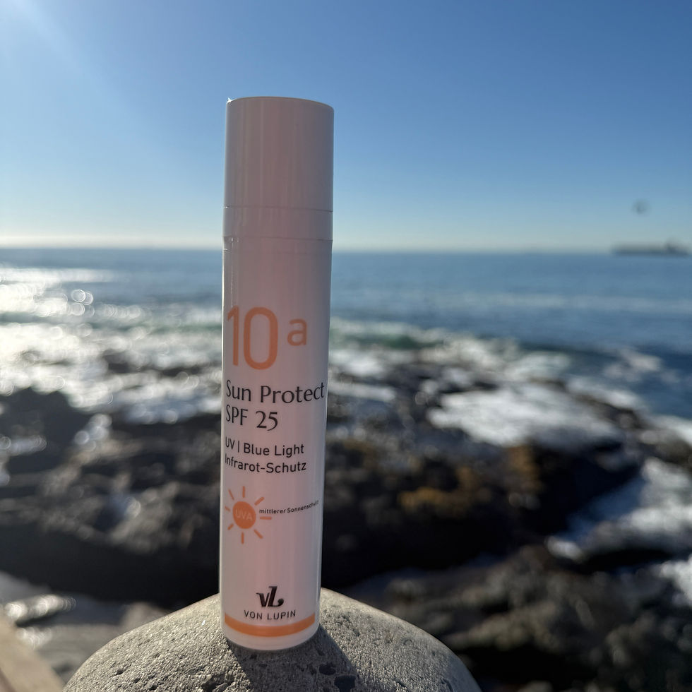 Sonnencreme steht auf einem Felsen im Hintergrund das Meer.